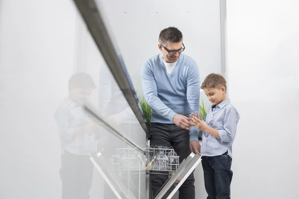 Apa és fia üveg elhelyezése mosogatógép — Stock Fotó