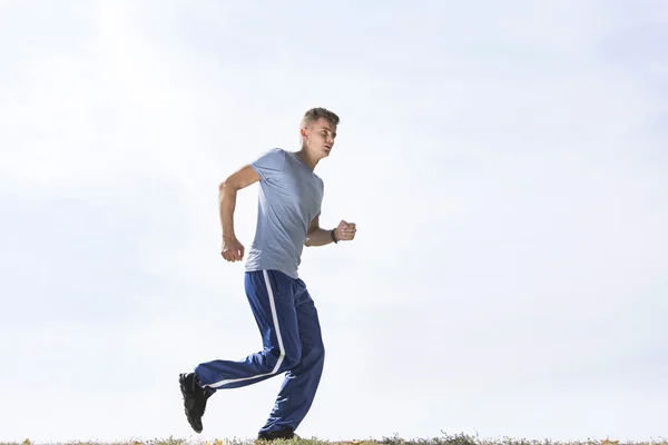 Hombre corriendo contra el cielo — Foto de Stock