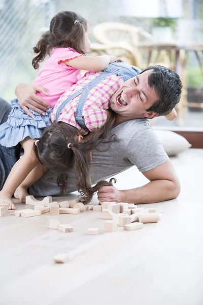 Hijas juguetonas encima del padre — Foto de Stock