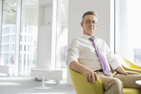 Businessman sitting in office lobby — Stock Photo, Image