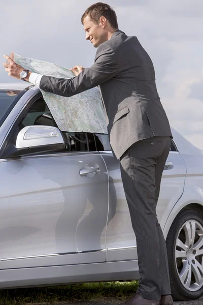 Businessman reading map — Stock Photo, Image