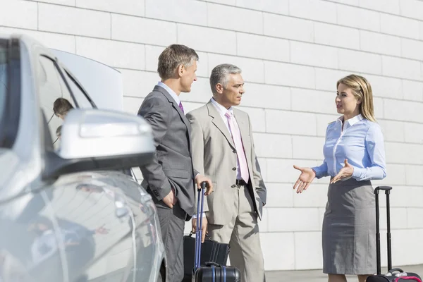 Businesspeople with luggage discussing — Stock Photo, Image