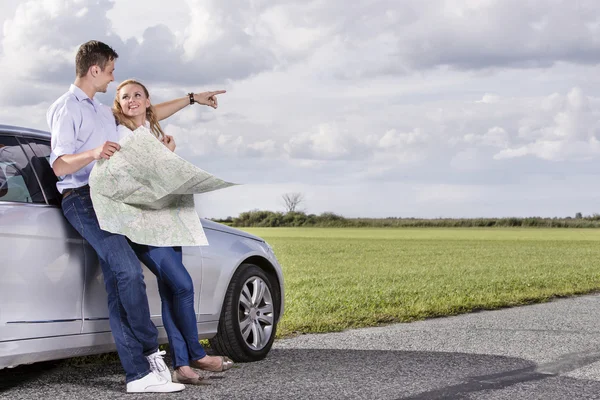 Couple with map discussing direction — Stock Photo, Image