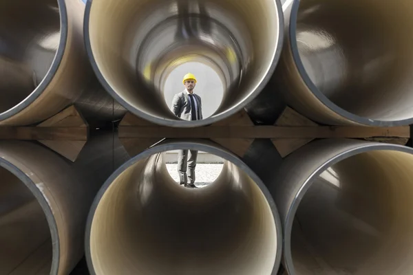 Architect through stacked pipes — Stock Photo, Image