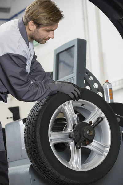 Mechanic repairing car's wheel — Stock Photo, Image