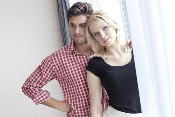 Couple standing  by hotel window — Stock Photo, Image
