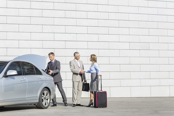 Businesspeople with luggage shaking hands — Stock Photo, Image