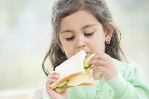Девочка ест сэндвич — стоковое фото