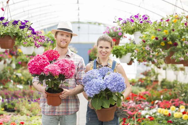 Trädgårdsmästare håller blomkrukor — Stockfoto