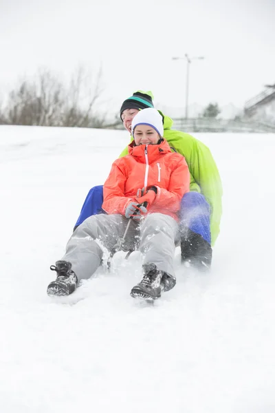 Couple sledging on snow — Stock Photo, Image