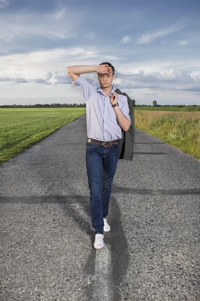 Hombre caminando solo en camino rural — Foto de Stock