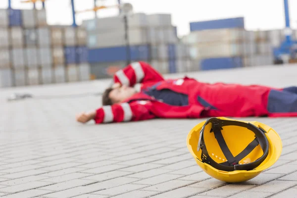 Male worker lying in shipping yard — Stock Photo, Image