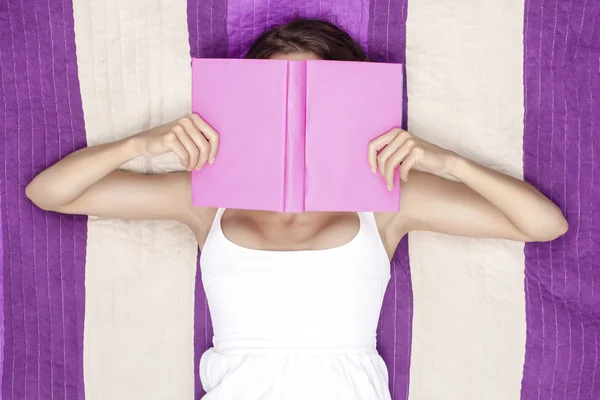 Frau bedeckt Gesicht mit Buch — Stockfoto