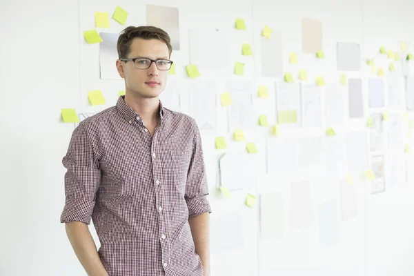 Confident businessman standing against whiteboard — Stock Photo, Image