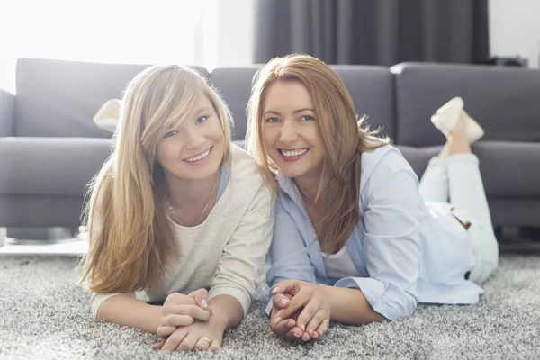 Mother and daughter lying on carpet — Stock Photo, Image