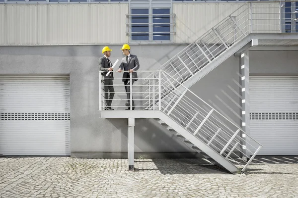 Бизнесмены обсуждают на лестнице — стоковое фото