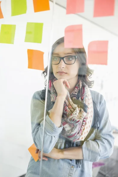 Businesswoman reading sticky notes — Stock Photo, Image