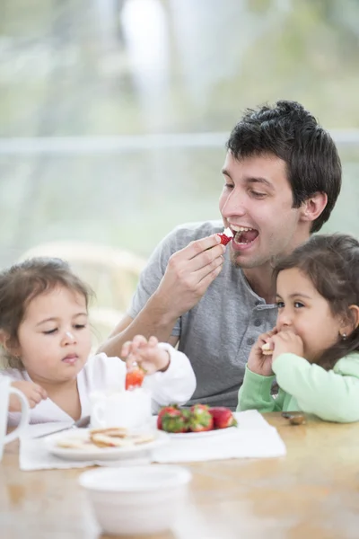 Padre e hijas comiendo fresas —  Fotos de Stock