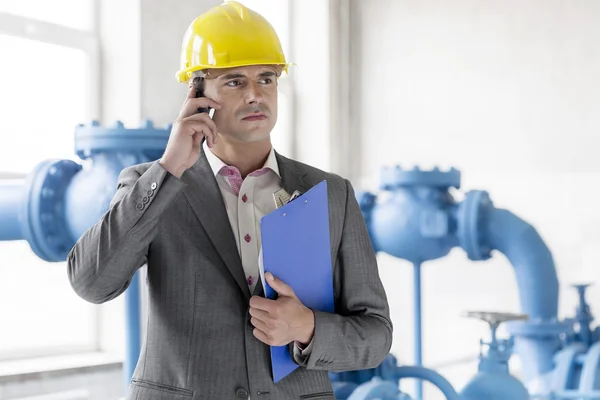 Supervisor com área de transferência usando telefone celular — Fotografia de Stock