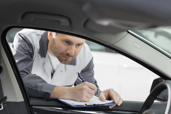 Mecânico verificando o interior do carro — Fotografia de Stock