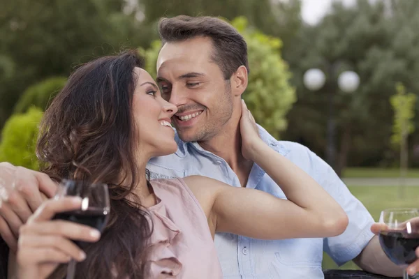 Молодая пара с бокалами вина в парке — стоковое фото