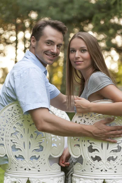 Couple sitting on chairs in park — Stock Photo, Image