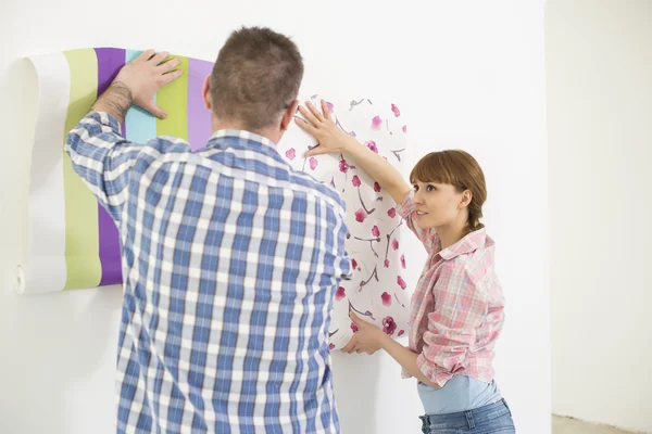 Couple holding up wallpaper — Stock Photo, Image