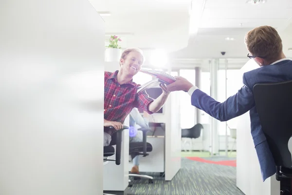 Businessman giving files to colleague — Stock Photo, Image