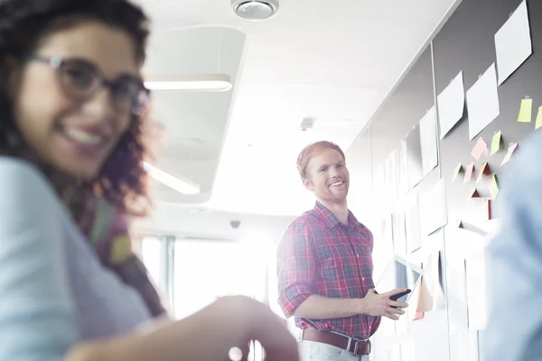 Hombre de negocios sonriente con colega femenina — Foto de Stock