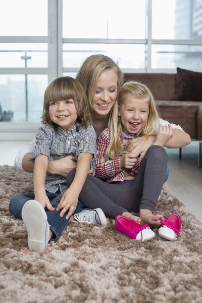 Mother with children sitting on rug