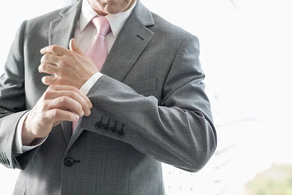 Businessman buttoning sleeve — Stock Photo, Image