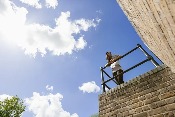 Woman leaning on railing — Stock Photo, Image