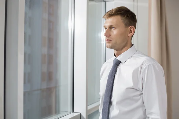 Businessman looking through window — Stock Photo, Image