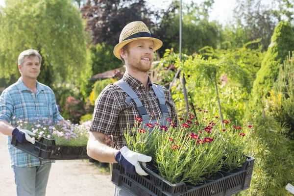Jardineiros carregando vasos de flores — Fotografia de Stock