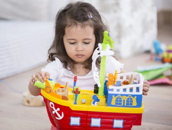 Girl playing with toy ship — Stock Photo, Image