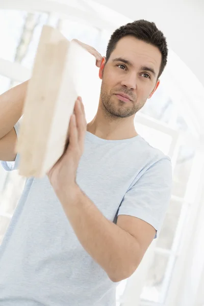 Hombre portando tablón de madera — Foto de Stock