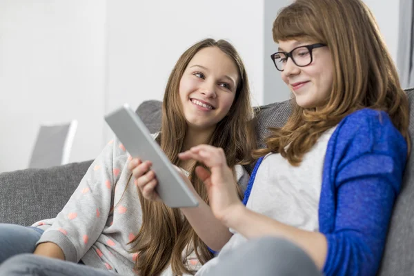 Glad tjej tittar på syster med digital tablet — Stockfoto