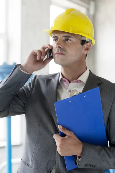 Supervisor com área de transferência usando telefone celular — Fotografia de Stock