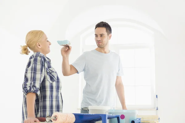 Man putting paint on woman's nose — Stock Photo, Image