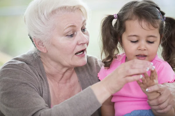 Woman helping granddaughter — Stock Photo, Image