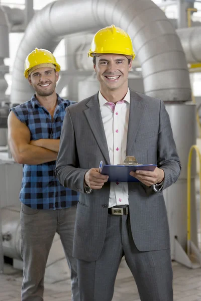 Manager holding clipboard with worker — Stock Photo, Image