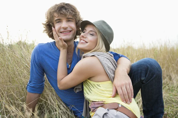 Loving couple relaxing in field — Stock Photo, Image