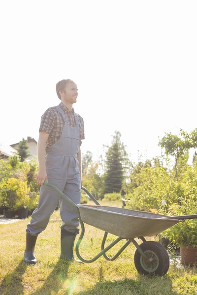 Man pushing wheelbarrow — Stock Photo, Image