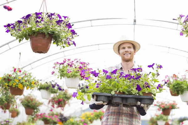 Jardineiro segurando vasos de flores — Fotografia de Stock
