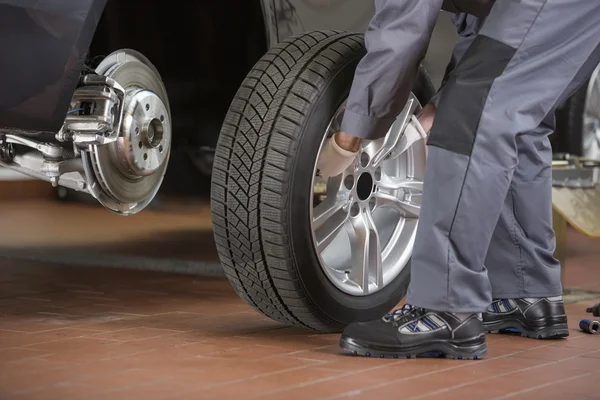 Repairman fixing car's tire — Stock Photo, Image