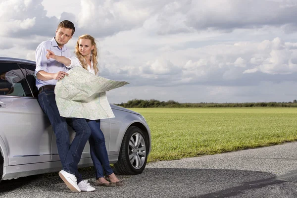 Couple with map discussing direction — Stock Photo, Image