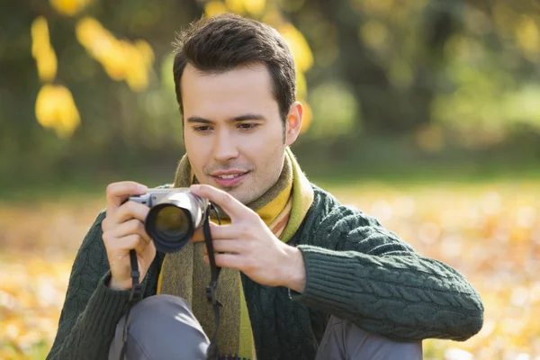 Człowiek ogląda fotografie w cyfrowy aparat fotograficzny — Zdjęcie stockowe