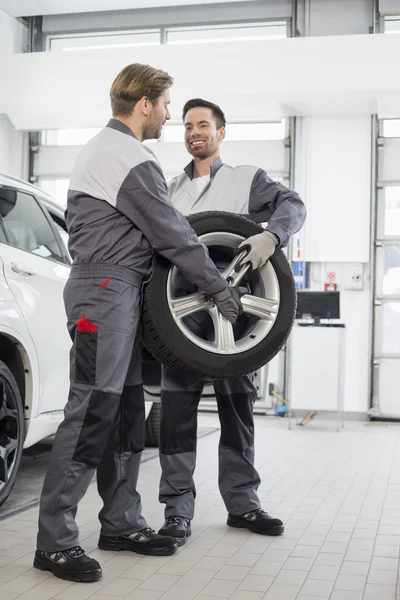 Maintenance engineers carrying tire — Stock Photo, Image
