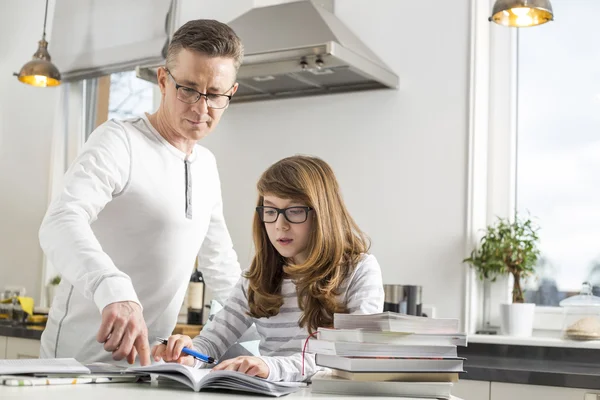 Padre che assiste la figlia nel fare i compiti — Foto Stock