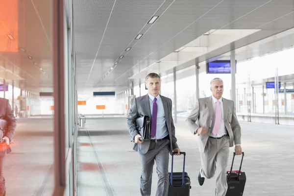 Businessmen with luggage rushing